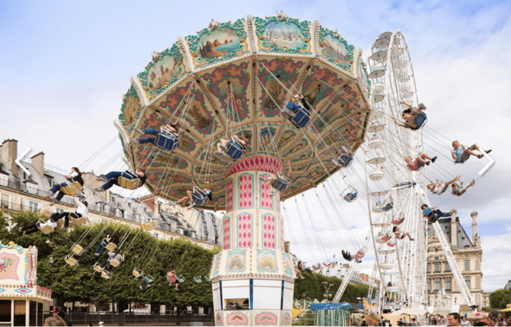 A large swing and a giant Ferris Wheel at the La Fête Foraine des Tuileries in Paris in July. 