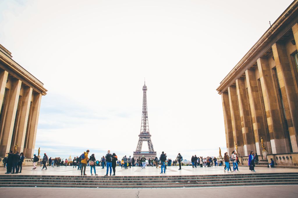 The Eiffel Tower with many people walking in the foreground.