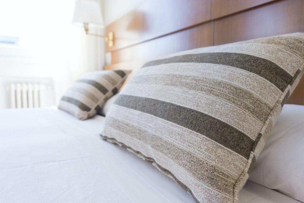 A stripped pillow on a hotel bed.