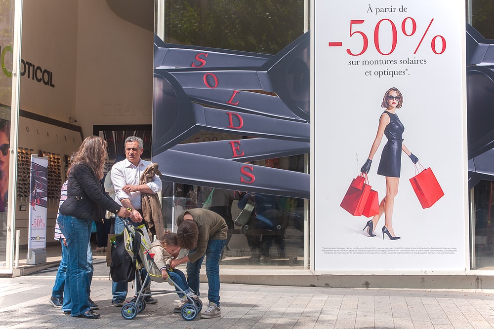 Shopping window in Paris, people shopping the many summer sales.