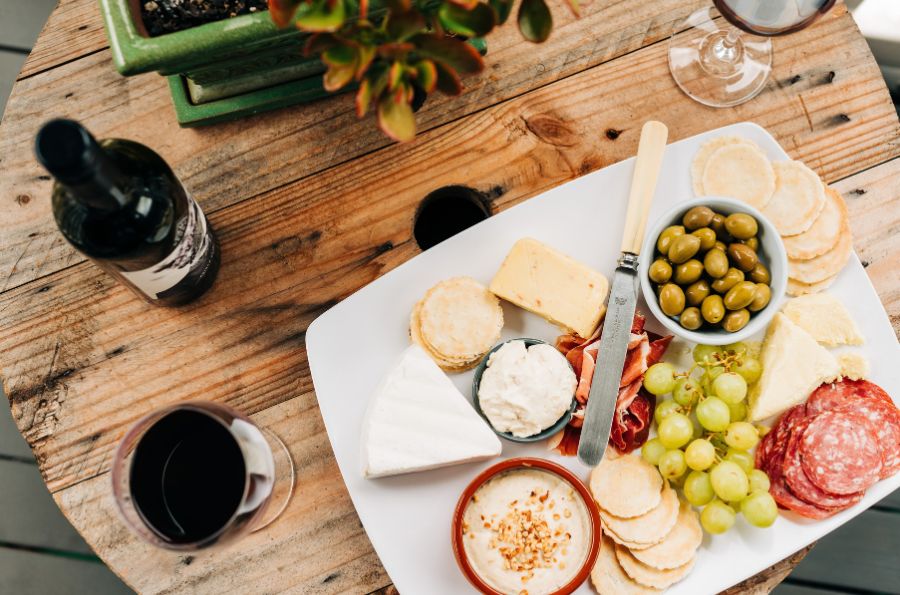 A cheeseboard and a bottle of wine.