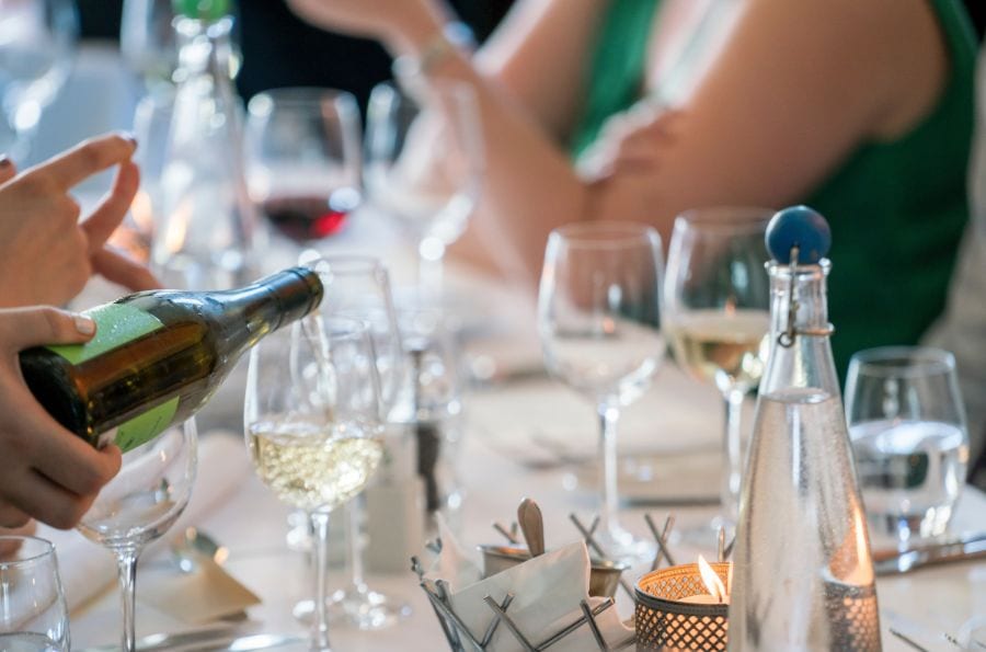 Many glasses of wine and empty glasses sit on a table.