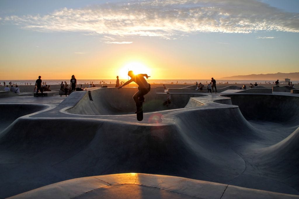 a skateboarder skating at Venice Beach Skatepark, California. What are the best Santa Cruz longboards? We have a list.