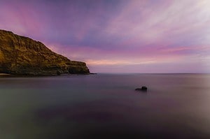 A pink and purple sky over Sunset Cliffs Natural Park.