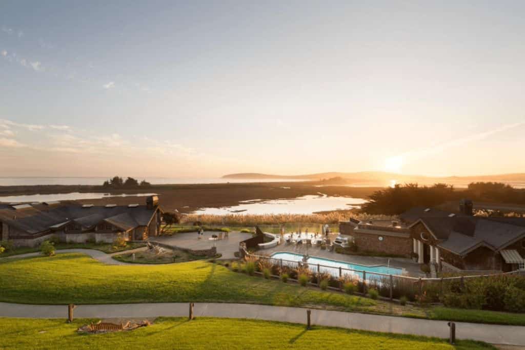 The Lodge at Bodega Bay, buildings and very green grass surrounding a pool. 