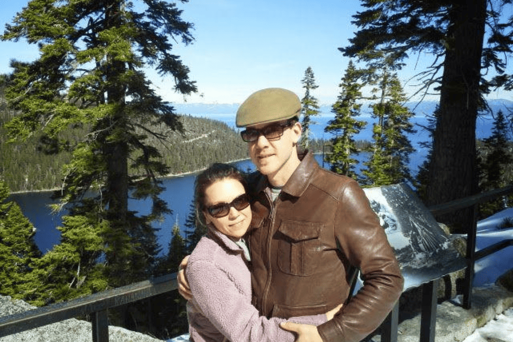 A man and a woman posing in front of Lake Tahoe. 