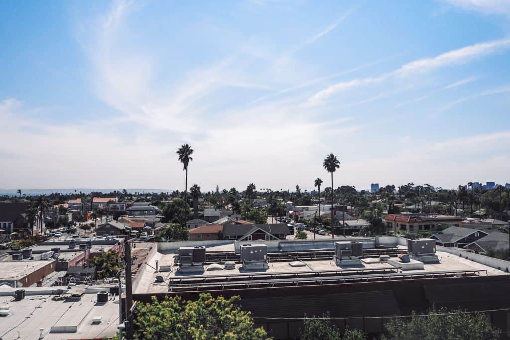 The top of buildings, palm trees on a sunny day in California. 