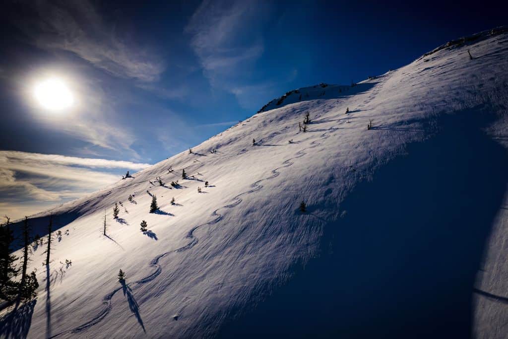 A side of a mountain in Lake Tahoe with a lot of snow on it. 