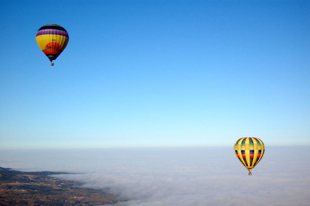 Two hot air balloon soar in the air.