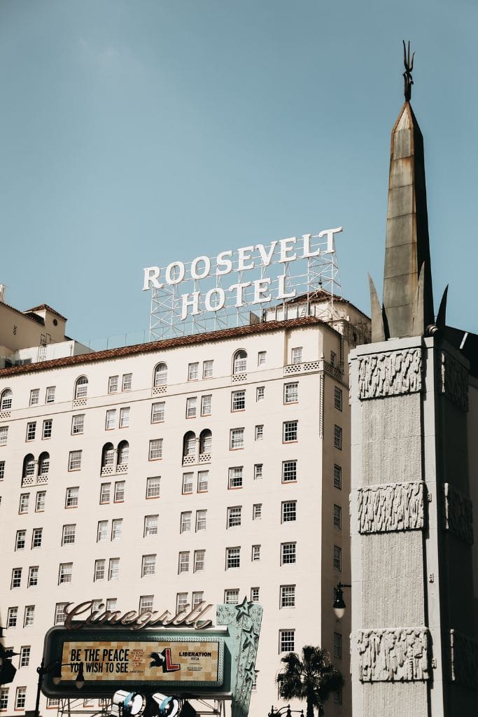 A white building with the sign "Roosevelt Hotel" on the top, on Hollywood Boulevard, Los Angeles, California.