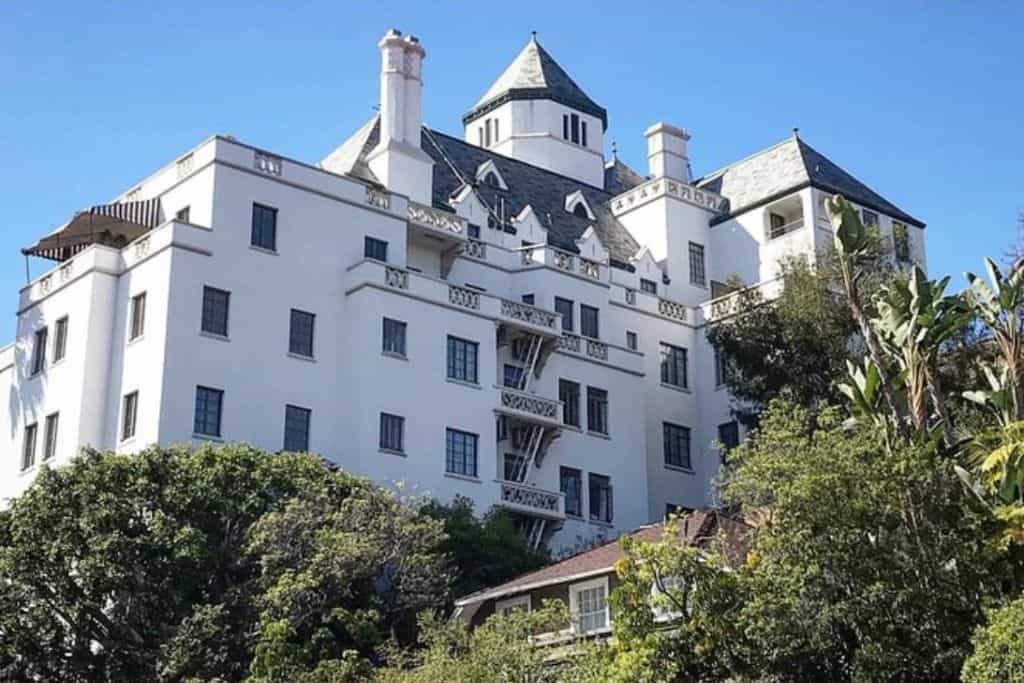 A large white building surrounded by trees.