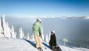 Two skiers at the top of a mountain.