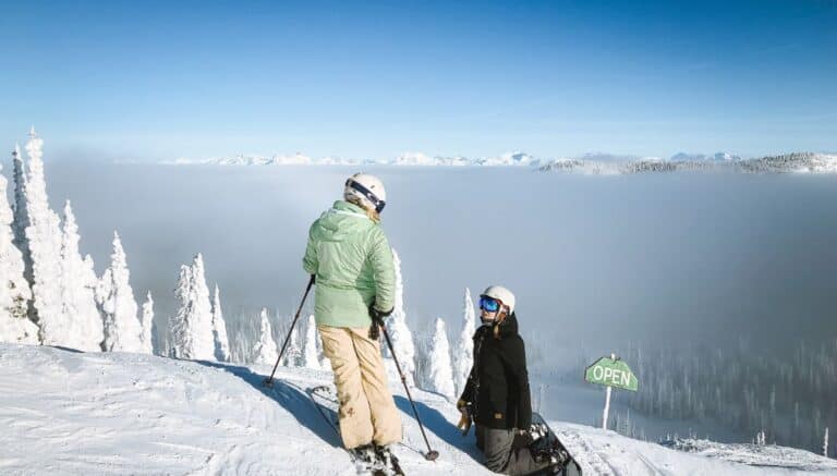 Two skiers at the top of a mountain.