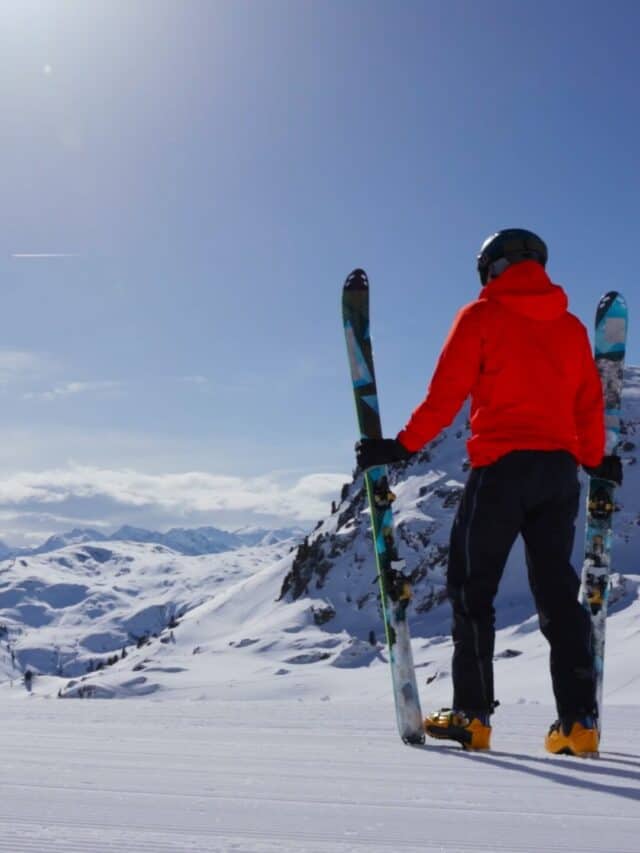 A skier on top of a snowy mountain.
