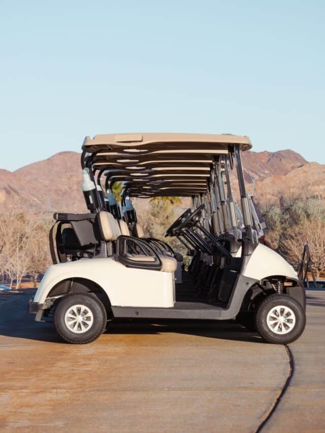 Several golf carts sitting in a row.