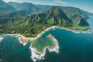 An aerial view of Kauai with water and a lush green island.
