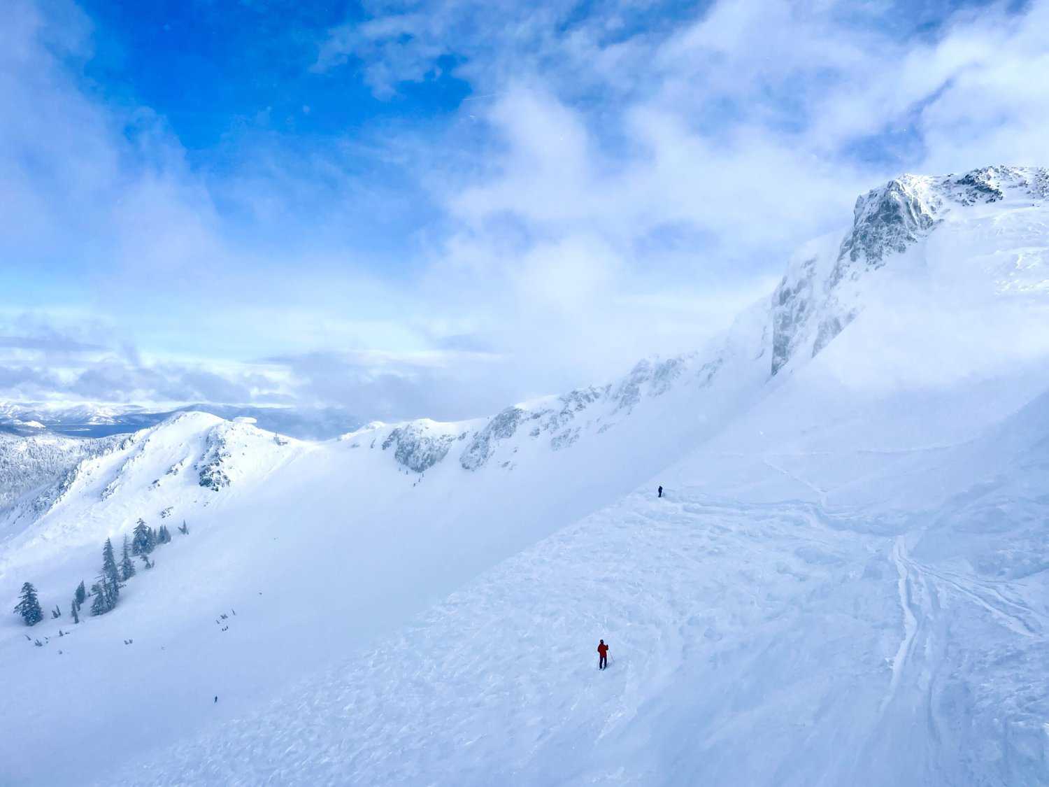 A skier skiing down the mountain at Palisade Tahoe, one of the snowiest mountains in California. 