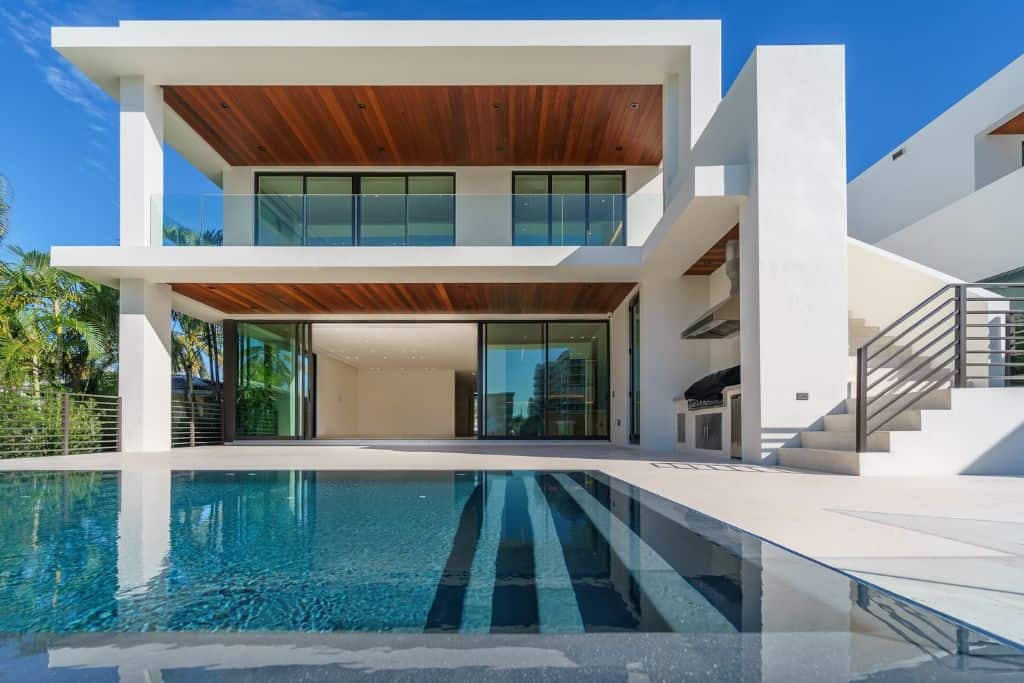 A pool next to a nice modern house.