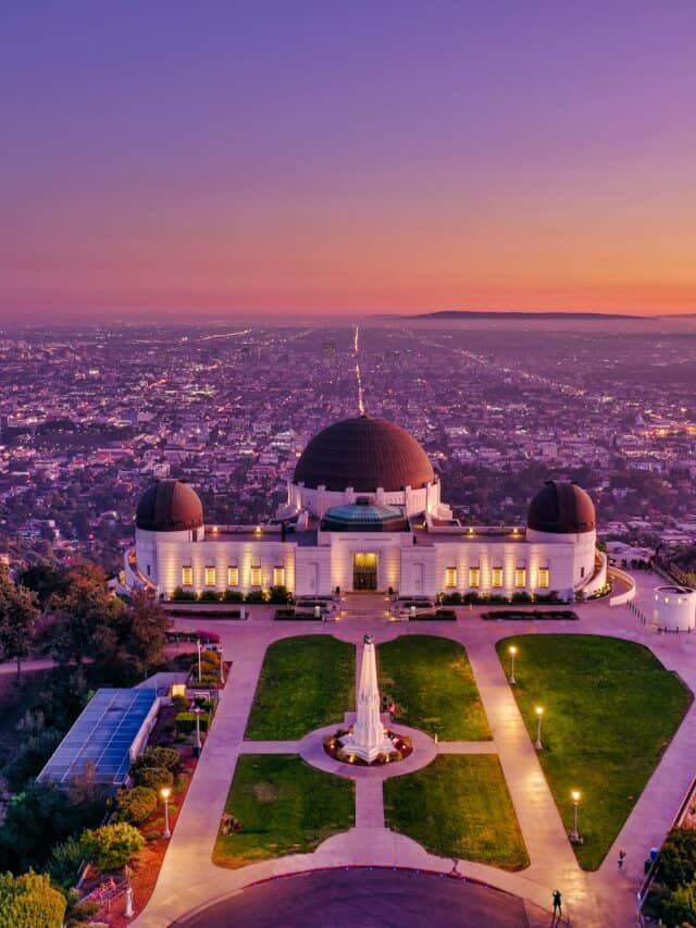 The Griffith Observatory at sunset with the DTLA skyline in the background.